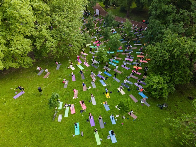 Vista aérea de la gente que hace yoga en el parque público de la ciudad