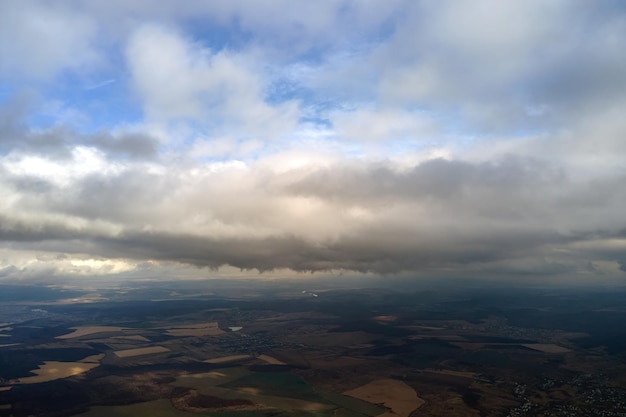 Vista aérea desde gran altura de la tierra cubierta de nubes lluviosas hinchadas que se forman antes de la tormenta