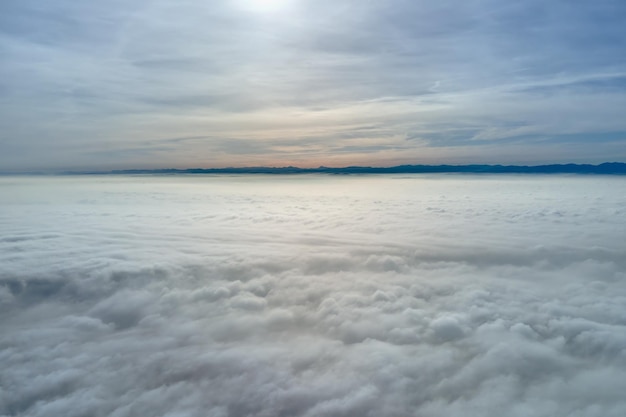 Vista aérea desde gran altura de la tierra cubierta de nubes lluviosas hinchadas que se forman antes de la tormenta