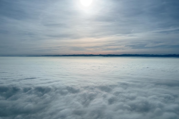 Vista aérea desde gran altura de la tierra cubierta de nubes lluviosas hinchadas que se forman antes de la tormenta