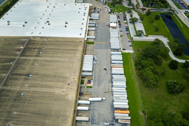 Vista aérea de una gran bahía de carga comercial con muchos camiones de reparto que descargan y cargan productos minoristas para su distribución en todo el país Concepto de economía global