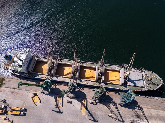 Foto vista aérea de un gran buque de carga cargado de grano de trigo en el puerto en un día soleado