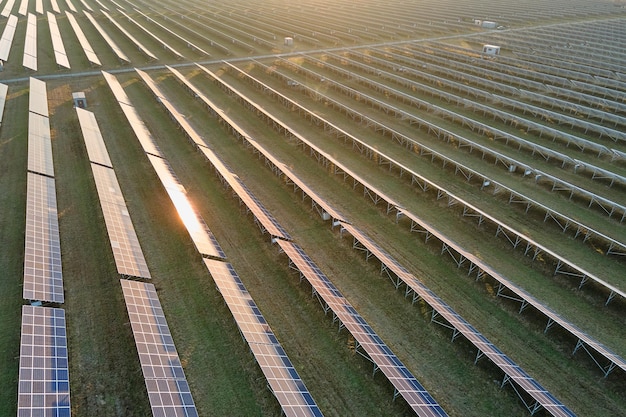 Vista aérea de una gran central eléctrica sostenible con filas de paneles fotovoltaicos solares para producir energía eléctrica limpia por la noche Concepto de electricidad renovable con cero emisiones