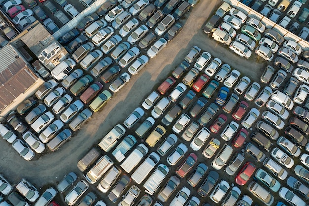 Vista aérea del gran estacionamiento del depósito de chatarra con filas de autos rotos desechados Reciclaje de vehículos viejos