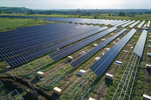 Vista aérea de una gran planta de energía eléctrica en construcción con muchas filas de paneles solares en una estructura metálica para producir energía eléctrica limpia Desarrollo de fuentes de electricidad renovables