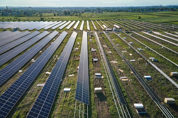 Vista aérea de una gran planta de energía eléctrica en construcción con muchas filas de paneles solares en una estructura metálica para producir energía eléctrica limpia Desarrollo de fuentes de electricidad renovables