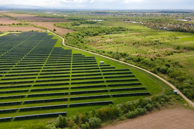Vista aérea de la gran planta de energía eléctrica sostenible con muchas filas de paneles solares fotovoltaicos para producir energía eléctrica ecológica limpia. Electricidad renovable con concepto de emisión cero.