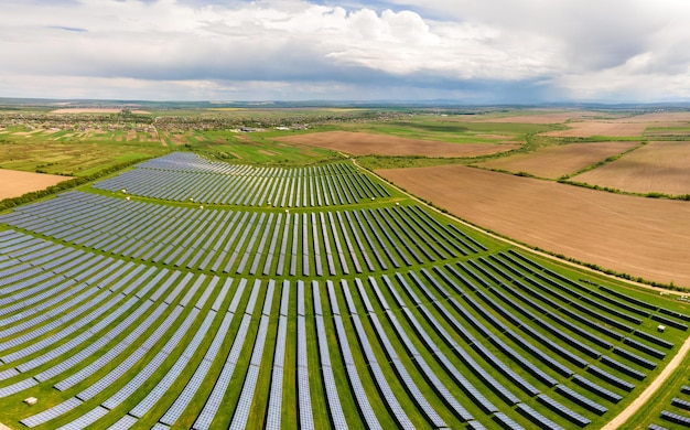 Vista aérea de la gran planta de energía eléctrica sostenible con muchas filas de paneles solares fotovoltaicos para producir energía eléctrica ecológica limpia. Electricidad renovable con concepto de emisión cero.