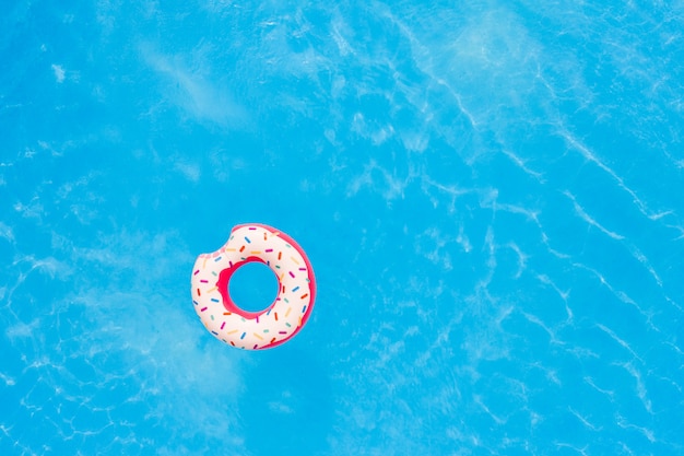 Vista aérea de gran rosquilla rosa en el fondo de la piscina