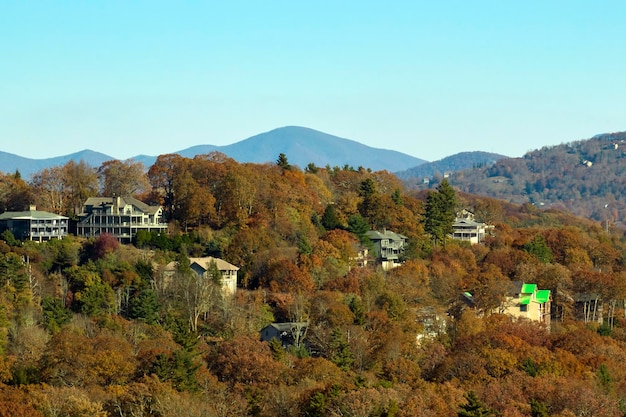 Vista aérea de grandes casas familiares en la cima de la montaña entre árboles amarillos en el área suburbana de Carolina del Norte en la temporada de otoño Desarrollo inmobiliario en los suburbios estadounidenses