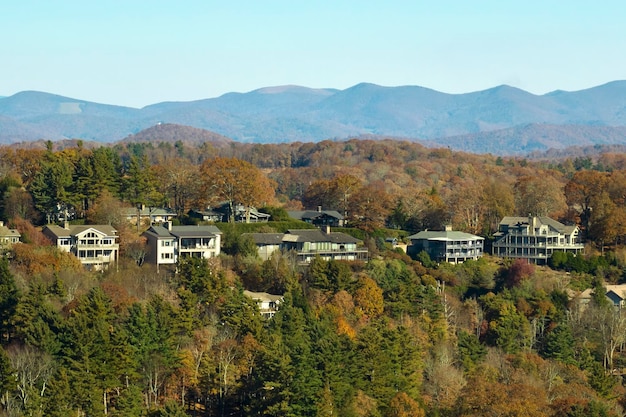 Vista aérea de grandes casas familiares en la cima de la montaña entre árboles amarillos en el área suburbana de Carolina del Norte en la temporada de otoño Desarrollo inmobiliario en los suburbios estadounidenses