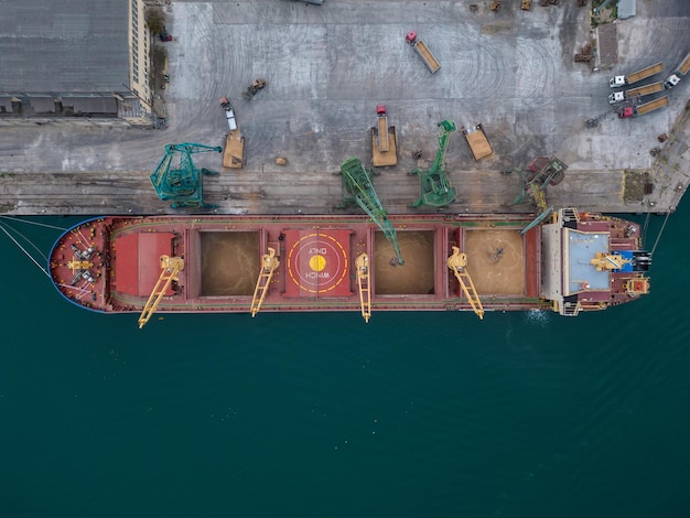 La vista aérea del granelero del buque de carga grande se carga con el grano de trigo en puerto