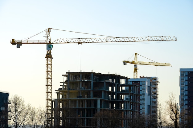 Vista aérea de grúas torre y altos edificios de apartamentos residenciales en construcción. Desarrollo inmobiliario.