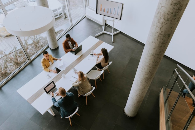 Vista aérea de un grupo de jóvenes empresarios multiétnicos que trabajan juntos y preparan un nuevo proyecto en una reunión en la oficina