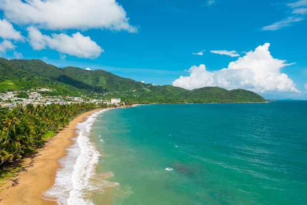 Una vista aérea de una hermosa playa en Maunabo, Puerto Rico contra un cielo azul nublado