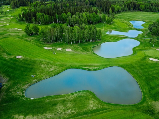 Vista aérea de la hierba verde en el campo de golf con estanques en Finlandia