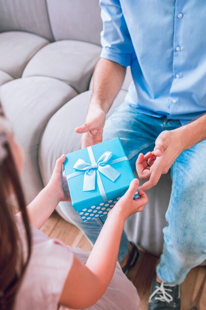 Vista aérea de la hija y el padre con caja de regalo en las manos