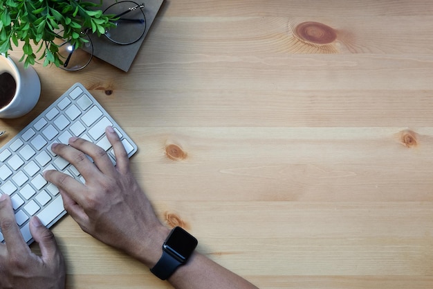 Vista aérea hombre independiente manos escribiendo en teclado inalámbrico