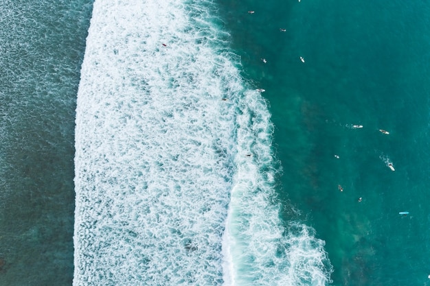 Vista aérea incrível Top down das ondas quebram no mar tropical Surfistas com pranchas de surf Vista aérea do drone das ondas do mar no belo oceano em Phuket, Tailândia.