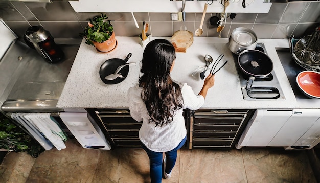 Vista aérea de un individuo en una cocina de espaldas con utensilios especializados para controlar los síntomas ...