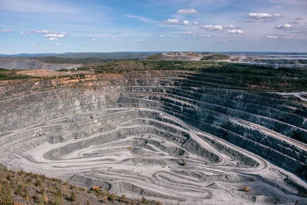 Vista aérea industrial de la cantera de minería a cielo abierto con mucha maquinaria en el trabajo - vista desde arriba. Extracción de cal, tiza, cal, caol