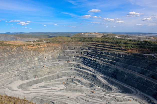 Vista aérea industrial de la cantera de minería a cielo abierto con mucha maquinaria en el trabajo - vista desde arriba. Extracción de cal, tiza, cal, caol