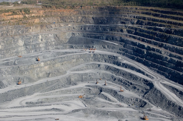 Vista aérea industrial de la cantera de minería a cielo abierto con mucha maquinaria en el trabajo - vista desde arriba. Extracción de cal, tiza, cal, caol