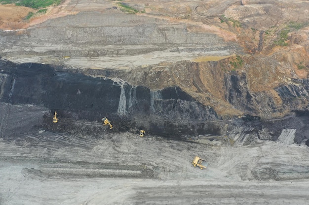 Vista aérea industrial de mineração de carvão a céu aberto com muitas máquinas no trabalho - vista de cima.