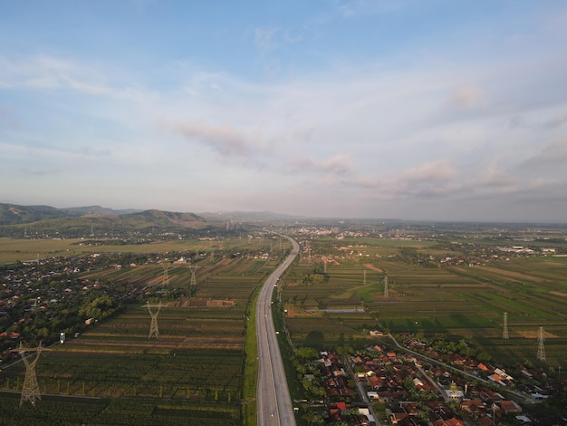 Vista aérea de Jalan Raya Indonesia con pocos autos y vista del amanecer