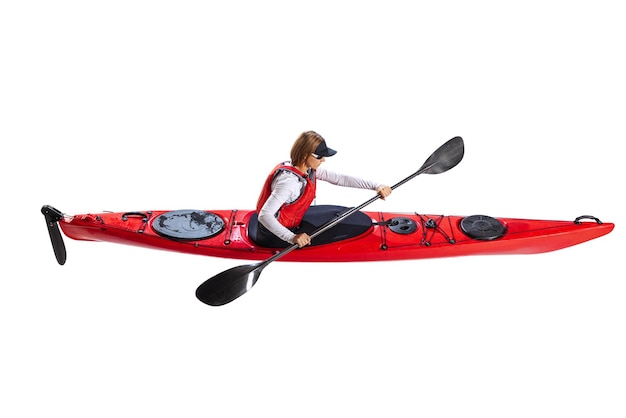 Vista aérea de una joven en kayak de canoa roja con un chaleco salvavidas y un remo aislado en blanco