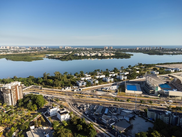 Vista aérea de la laguna de Jacarepaguá en Río de Janeiro Brasil Edificios residenciales y montañas alrededor del lago Playa de Barra da Tijuca en el fondo Día soleado Atardecer Drone foto