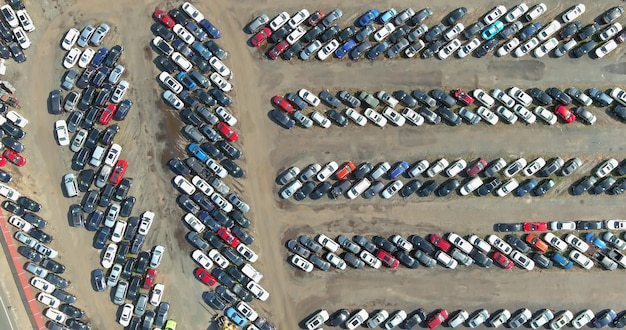 Vista aérea en el lote del concesionario de subastas de estacionamiento en una terminal de muchos autos usados