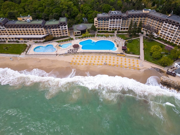 Vista aérea de un lujoso hotel con piscina frente al mar listo para recibir a los huéspedes al comienzo de la temporada