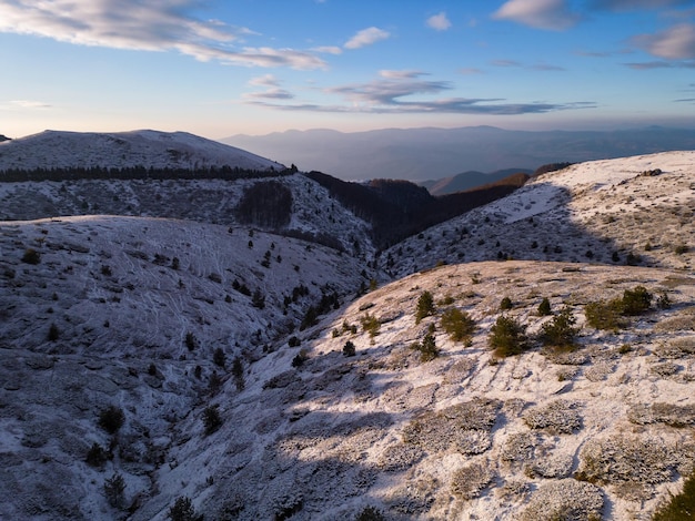 Vista aérea de la mañana de las montañas balcánicas cubiertas de nieve en la región del paso de Beklemeto