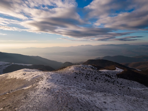 Vista aérea de la mañana de las montañas balcánicas cubiertas de nieve en la región del paso de Beklemeto