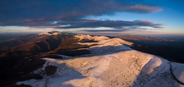 Vista aérea de la mañana de las montañas balcánicas cubiertas de nieve en la región del paso de Beklemeto