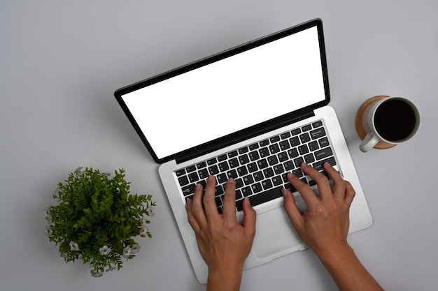 Vista aérea de las manos de la mujer escribiendo en la computadora portátil Pantalla en blanco para el texto publicitario