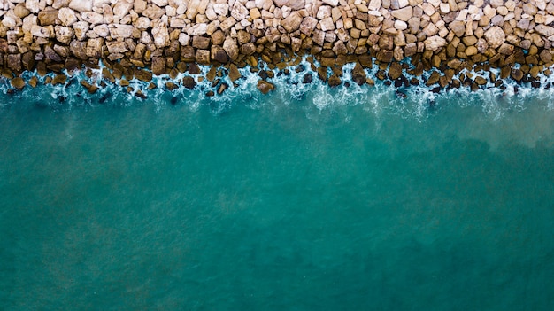 Vista aérea del mar chocando contra las rocas