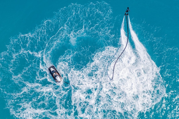 Vista aérea del mar de verano del deporte de acción extrema del agua de la tabla de moscas cerca del resort tropical de lujo