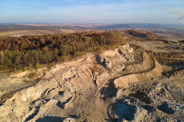 Vista aérea de la mina a cielo abierto de materiales de arenisca para la industria de la construcción con excavadoras y camiones volquete. Equipo pesado en minería y producción de concepto de minerales útiles.