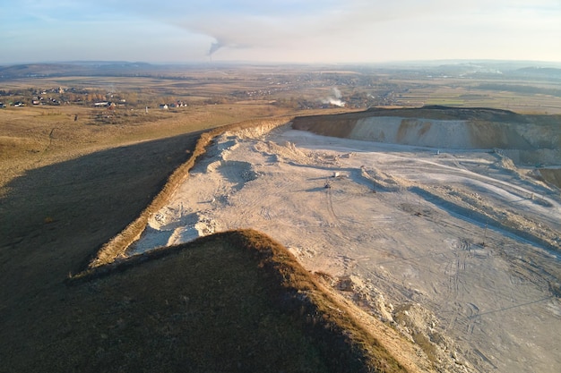 Vista aérea de la mina a cielo abierto de materiales de piedra arenisca para la industria de la construcción con excavadoras y volquetes. Equipo pesado en minería y producción de minerales útiles concepto