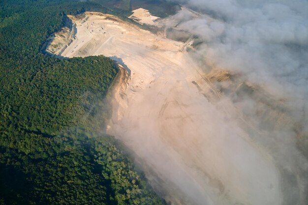 Vista aérea de la minería a cielo abierto de materiales de piedra caliza para la industria de la construcción con excavadoras y volquetes