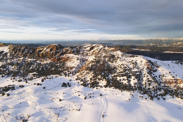 Vista aérea de las montañas cubiertas de nieve al atardecer