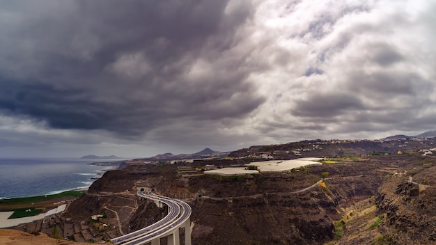 Vista aérea de las montañas de la isla de Gran Canaria y la costa junto al mar con nubes y niebla de fondo. España, Europa,