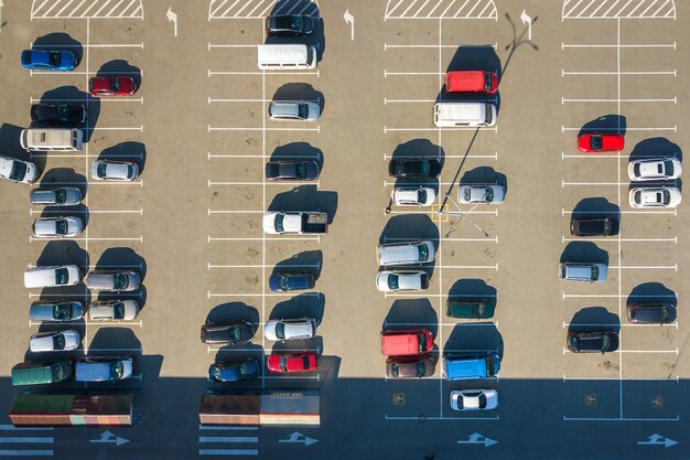 Vista aérea de muchos coches coloridos estacionados en el estacionamiento con líneas y marcas