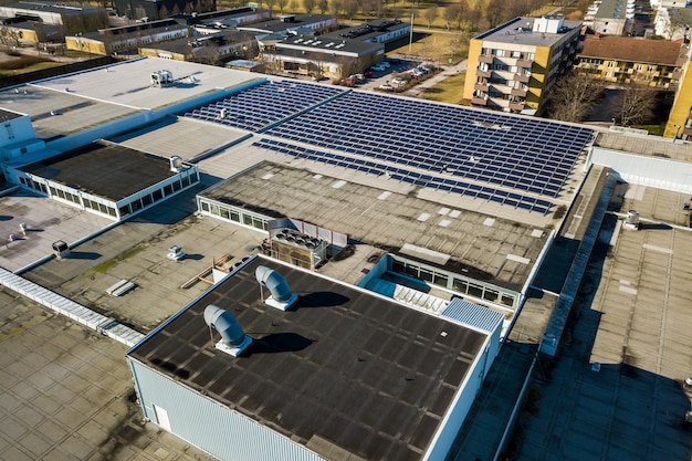 Vista aérea de muchos paneles solares fotovoltaicos montados del techo del edificio industrial.