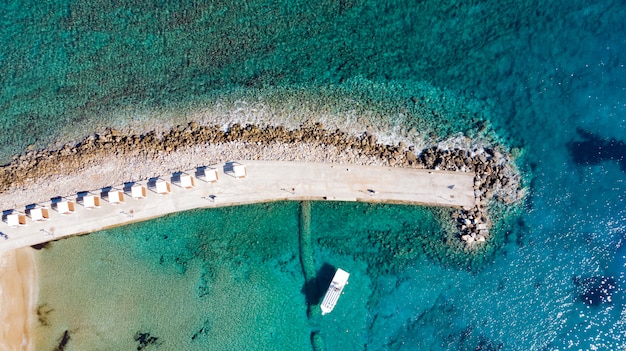 Vista aérea del muelle con rocas y acantilados al mar.