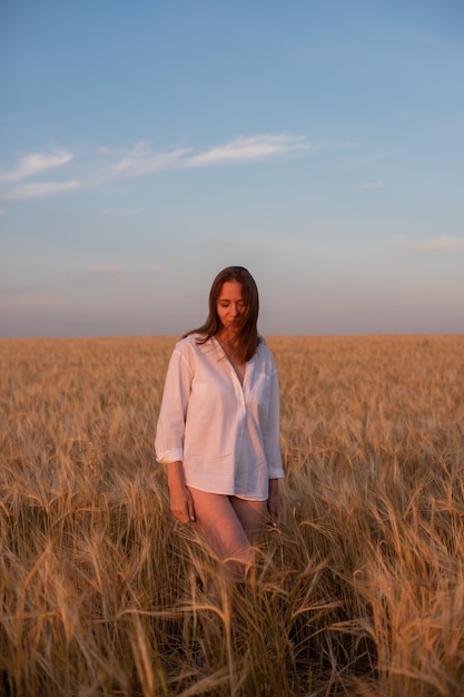 Vista aérea de la mujer acostada en el campo amarillo de trigo