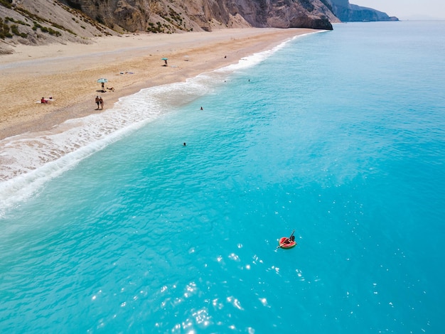 Vista aérea de la mujer de la playa de grecia flotando en el espacio de copia de anillo inflable