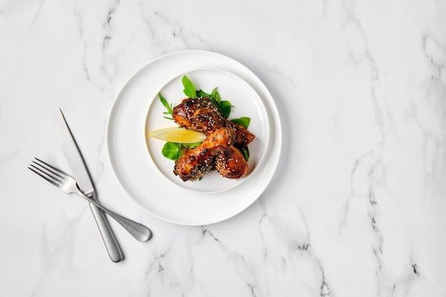 Vista aérea de muslos de pollo al horno con salsa picante en un plato